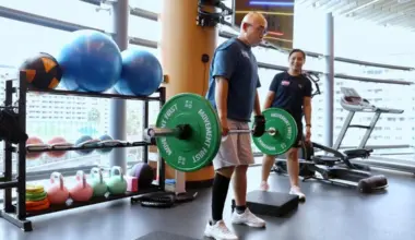 Stroke survivor Edmond Poh (left) using an assistive hand grip on his left hand while lifting weights under the watchful eyes of Exercise trainer Reosherra Lim. A year ago, he was could not have done this as he still needed a cane while walking.