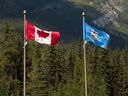 Flags of Alberta and Canada flutter in the wind.