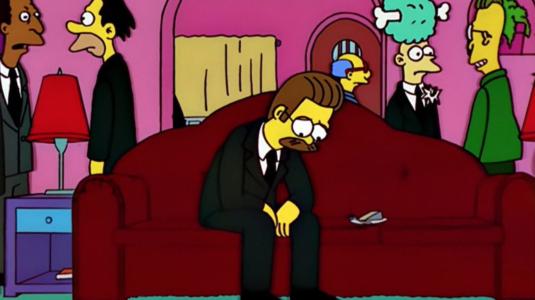 Ned Flanders sits on the couch sadly in 