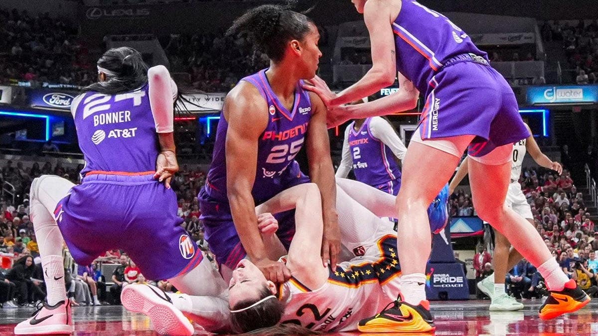 Phoenix Mercury forward Alyssa Thomas scrambling to get up over Indiana Fever guard Caitlin Clark during a basketball game