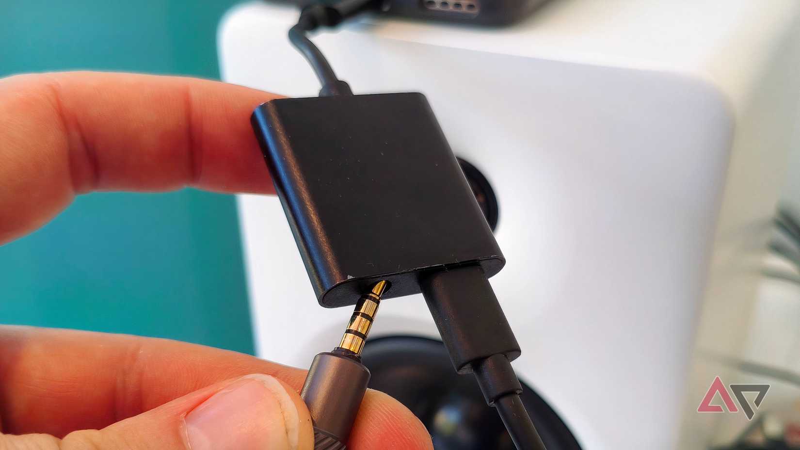 A USB-C / 3.5mm splitter plugged into an Android phone, a loudspeaker and a charger.