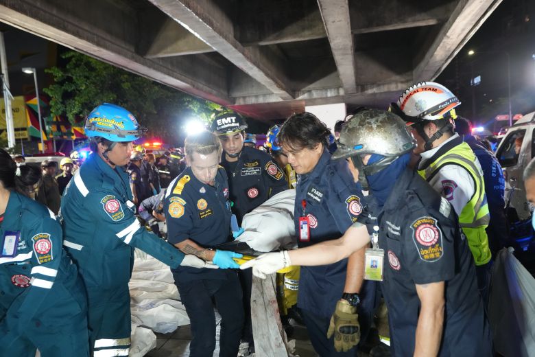 Rescuers carry the body of a victim of a fire in Bangkok, Thailand, Monday, July 13, 2026.