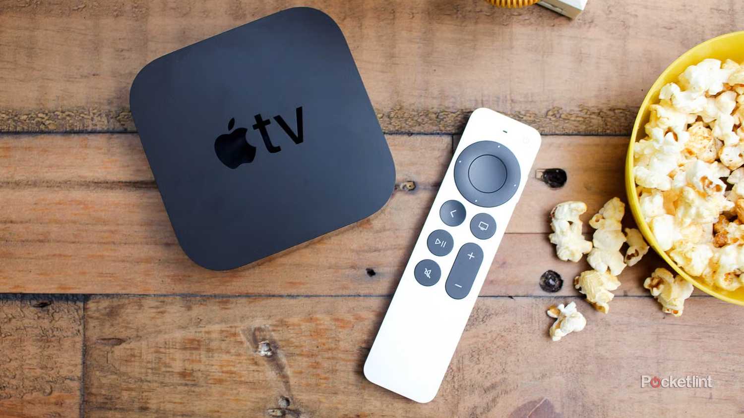 Apple TV 4K on table next to popcorn bowl.