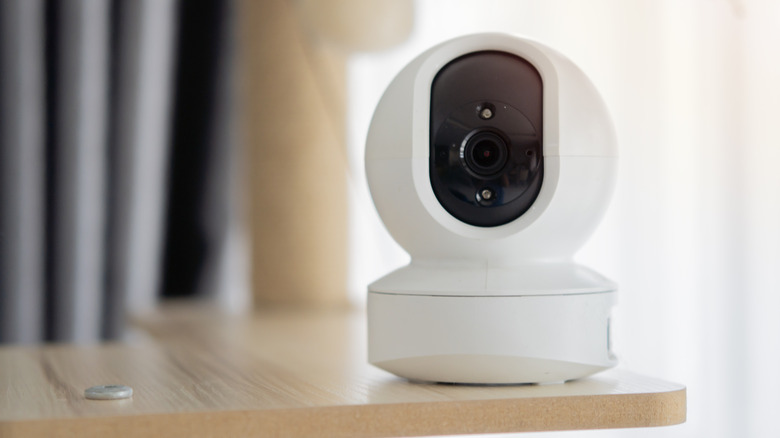 A CCTV smart camera placed on a wooden surface
