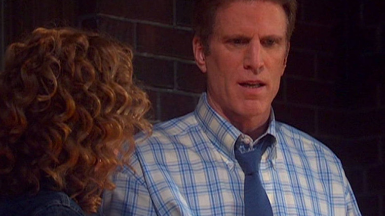 John Becker (Ted Danson) stands against a brick wall in Becker