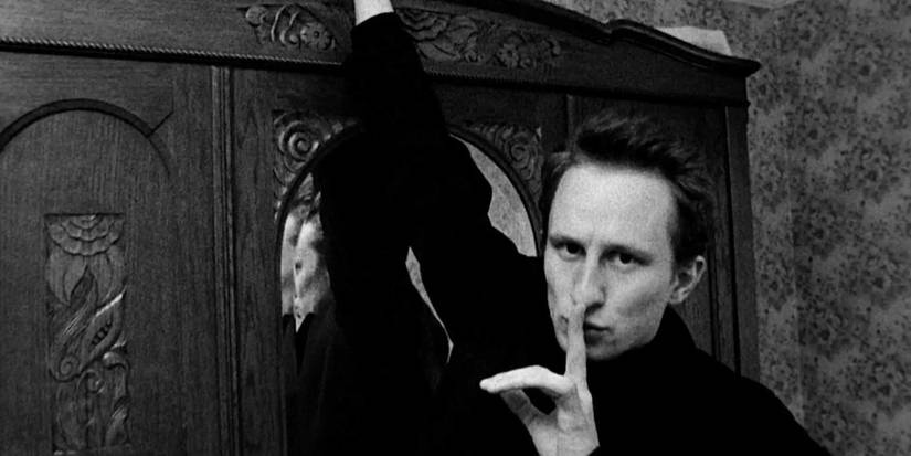 Ben (Benoît Poelvoorde) holds a finger to his lips to silence viewers in 'Man Bites Dog'.
