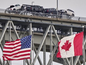 A truck with vehicles crosses the Blue Water Bridge border crossing into the United States from Sarnia, Ont., on April 3, 2025.