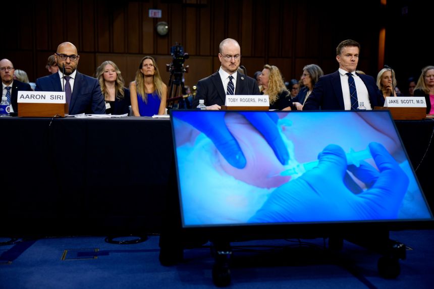 A child getting a shot is depicted on a video as attorney Aaron Siri, Brownstone Institute fellow Toby Rogers and Dr. Jake Scott, an infection disease specialist at Stanford University, appeared at a Senate subcommittee hearing in September.