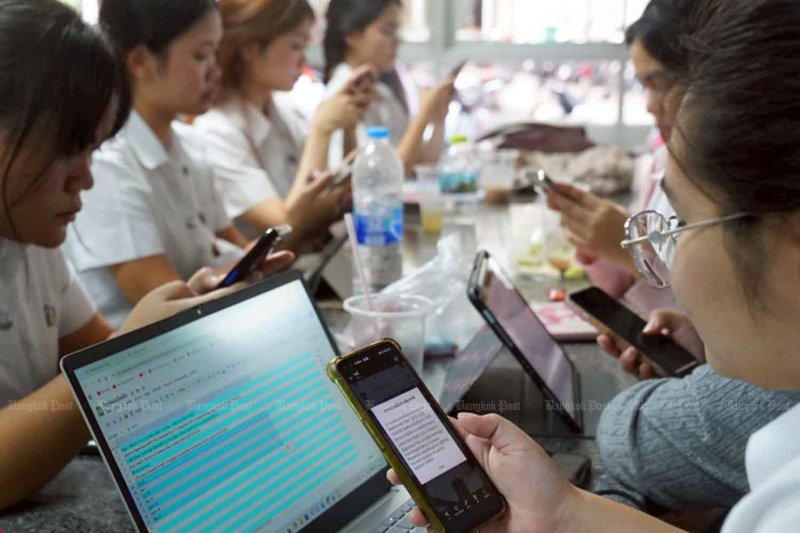 Students at a university in Bangkok use their mobile phones and tablets in January. Wisuttipong Rodpai
