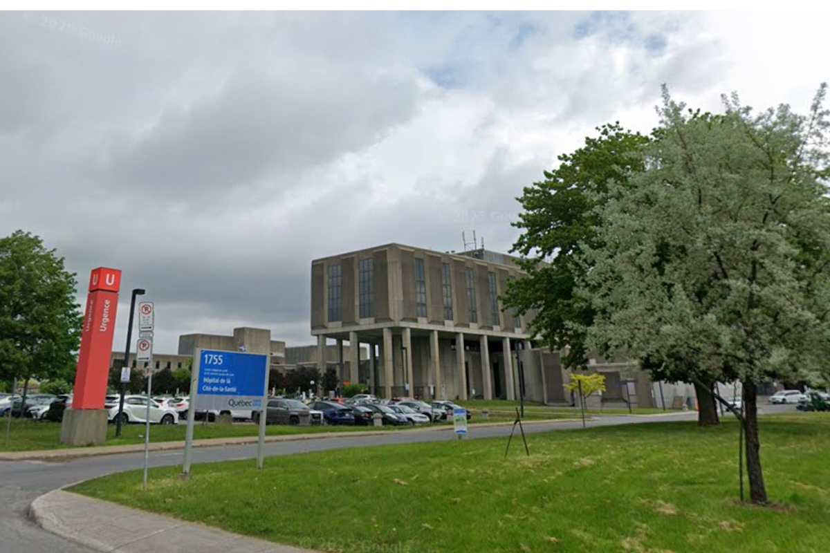The exterior of hospital grounds with an emergency sign to the left.
