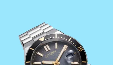 Close-up of a Citizen watch with a black bezel, gold-tone markers, and a stainless steel bracelet on a blue background.