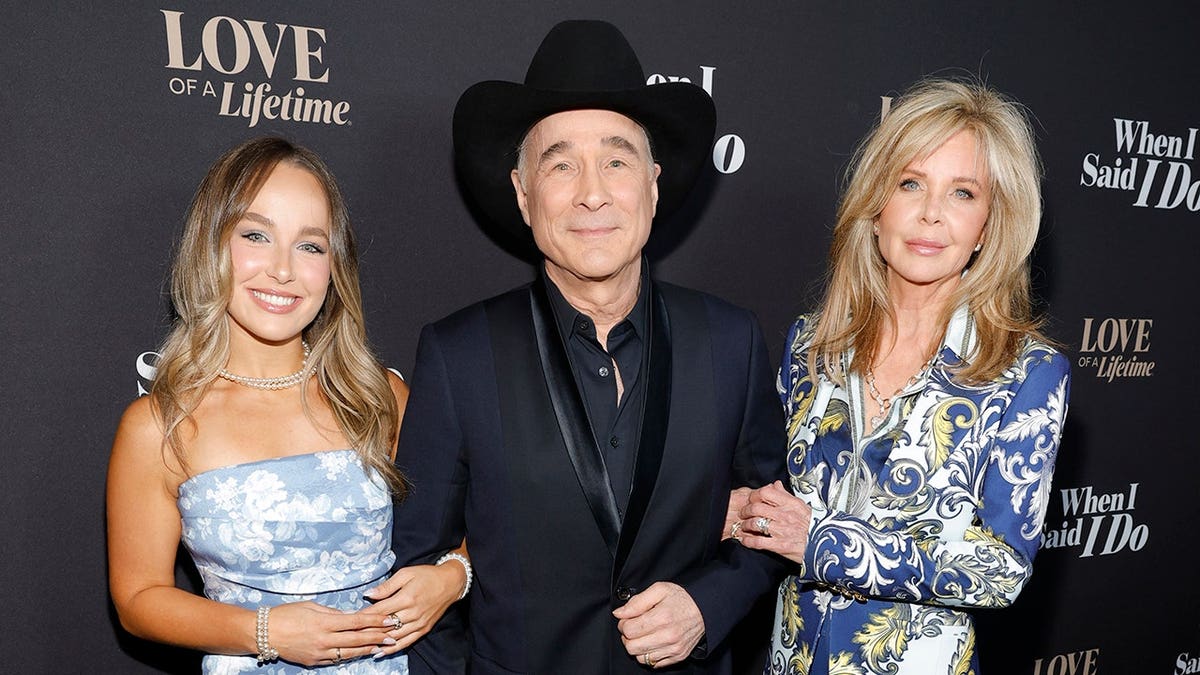 Clint Black standing with Lily Pearl Black and Lisa Hartman Black at an event