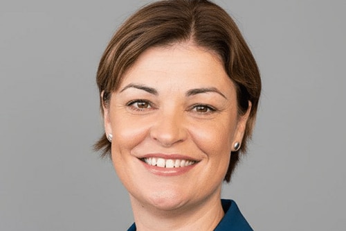 A woman with short brown hair, smiling.