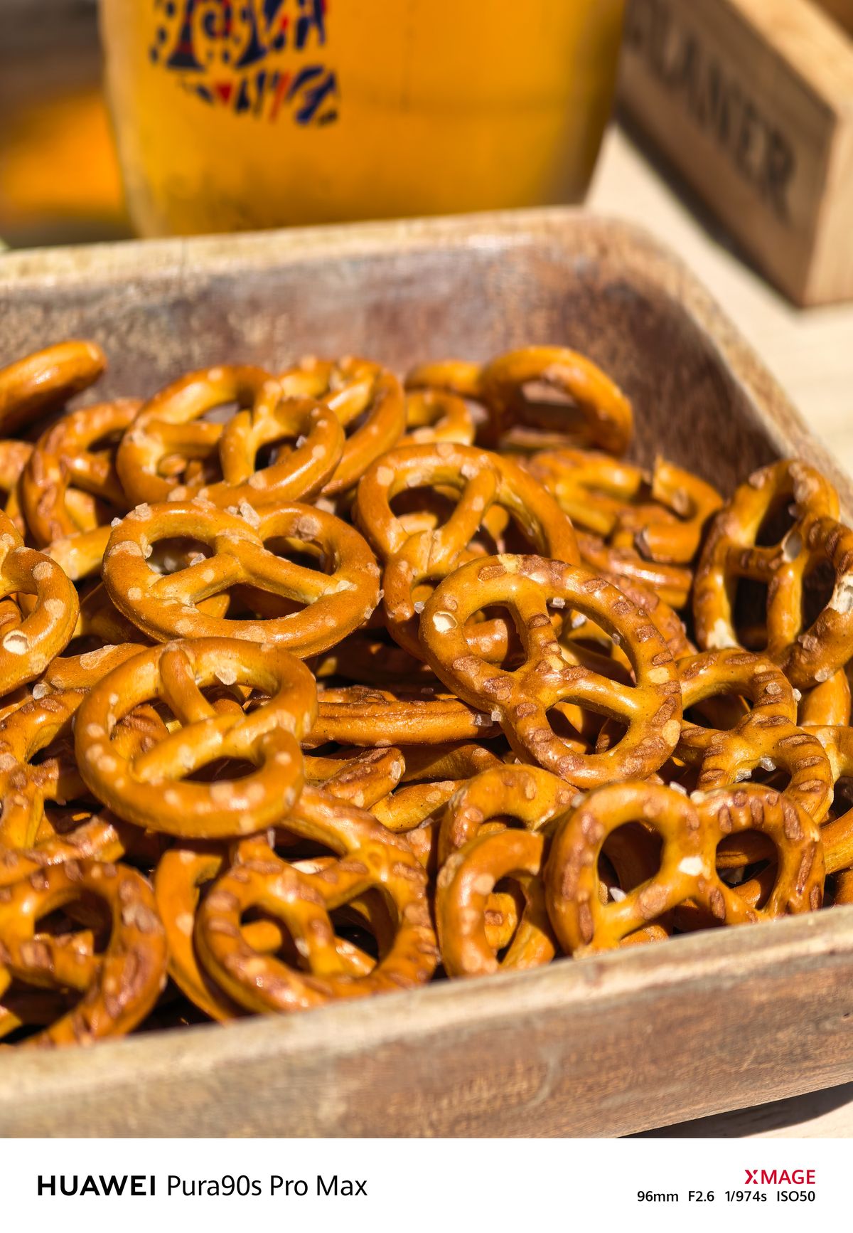 Close-up of salted pretzels piled inside a wooden serving tray.