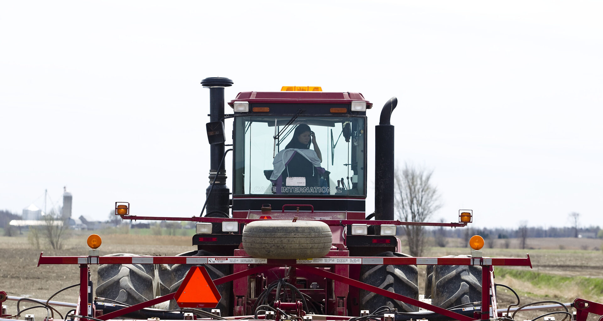 A farmer plows a field with a tractor.