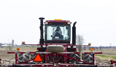 A farmer plows a field with a tractor.