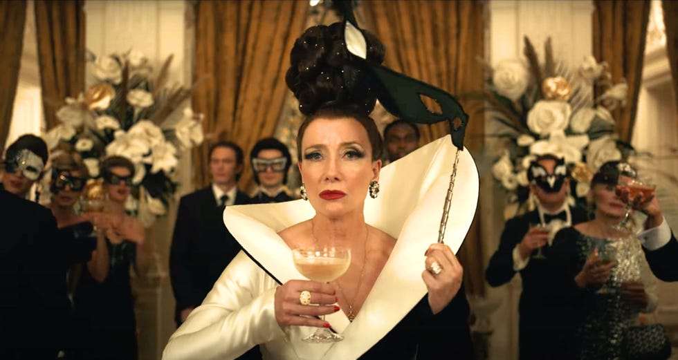 Disney's Cruella - Emma Thompson emma thompson holding a glass of champagne and a mask in disney's cruella