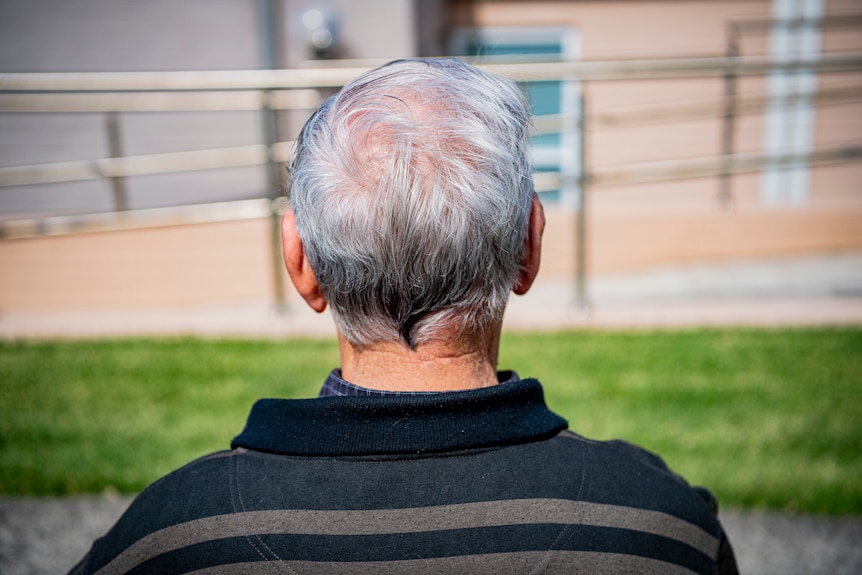 An elderly man is seen from behind