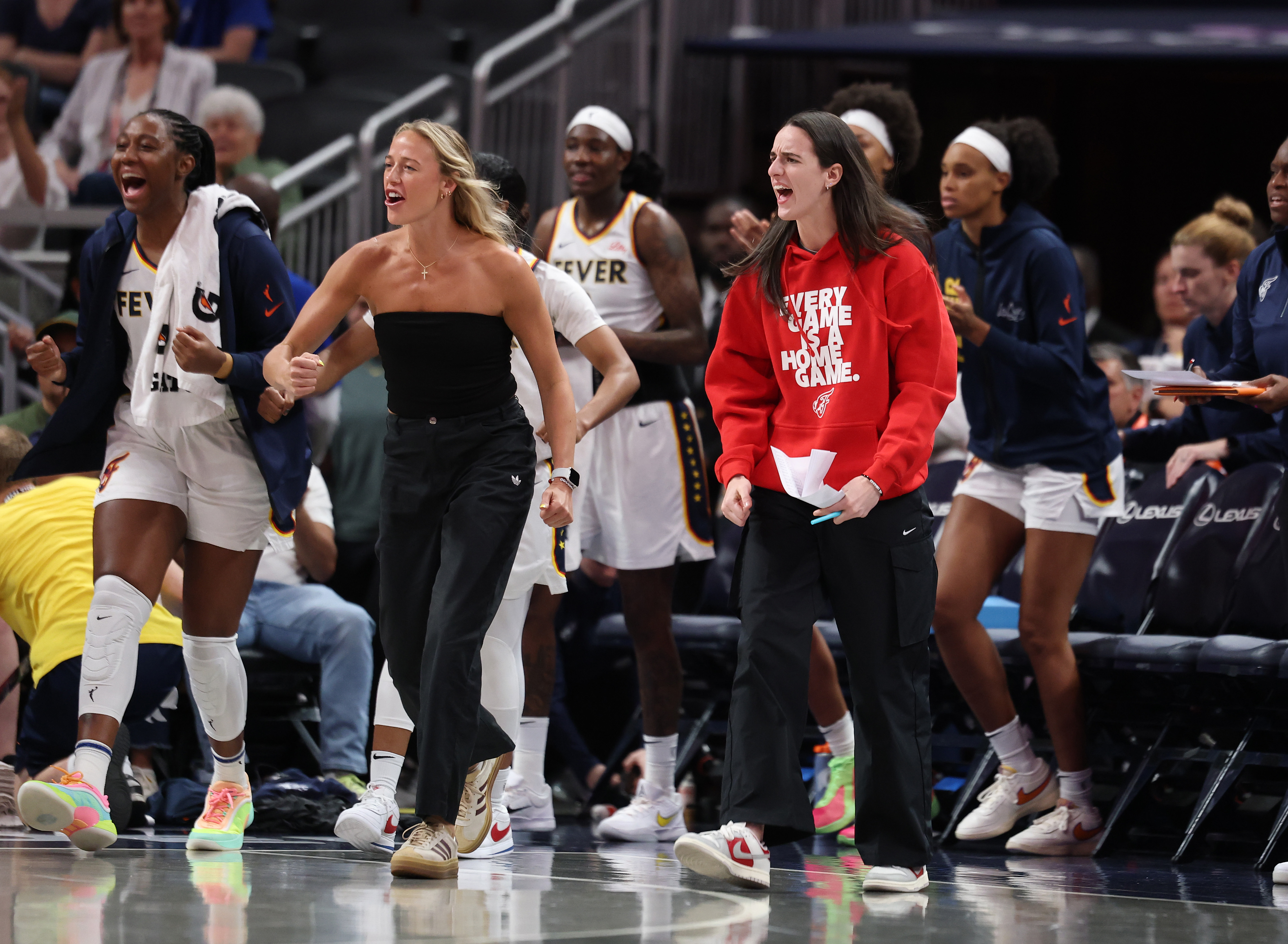 Caitlin Clark, Aliyah Boston, and Sophie Cunningham of the Indiana Fever celebrating during a game against the Washington Mystics