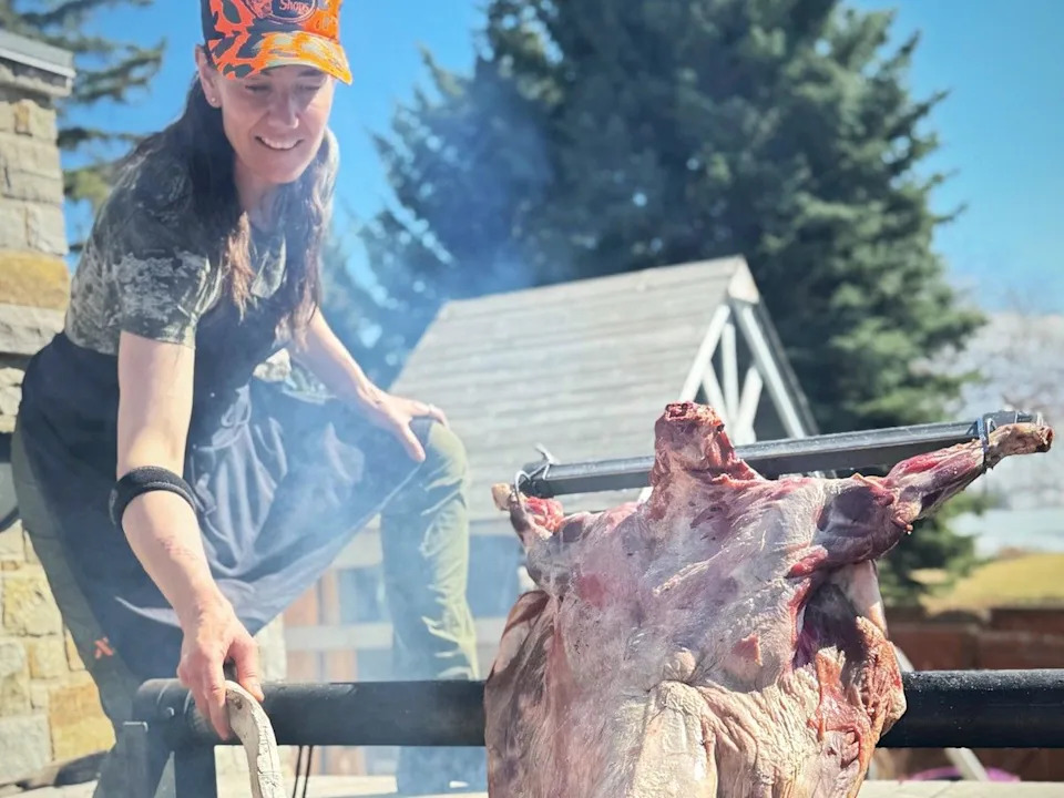 Connie DeSousa cooking lamb over live fire on an Argentine cross.