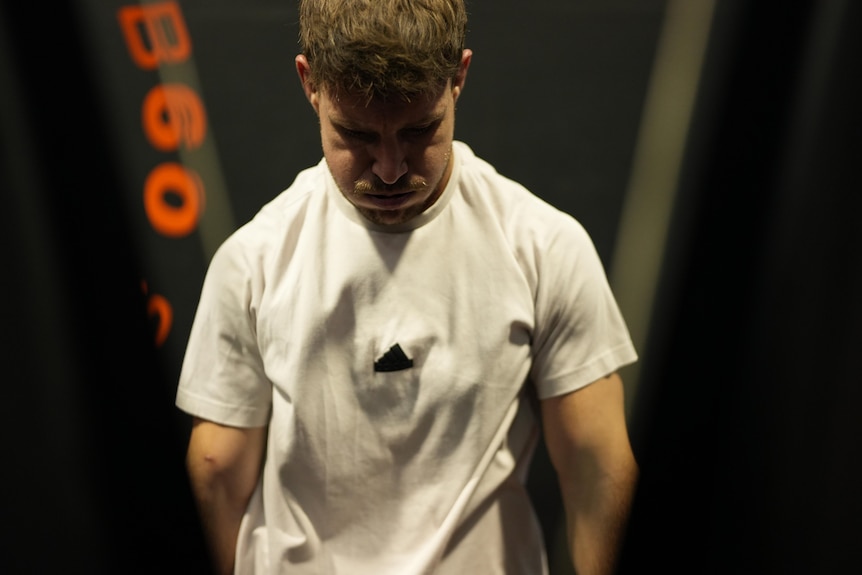 Luke Bateman breathes out heavy, hands down on a ski erg machine.