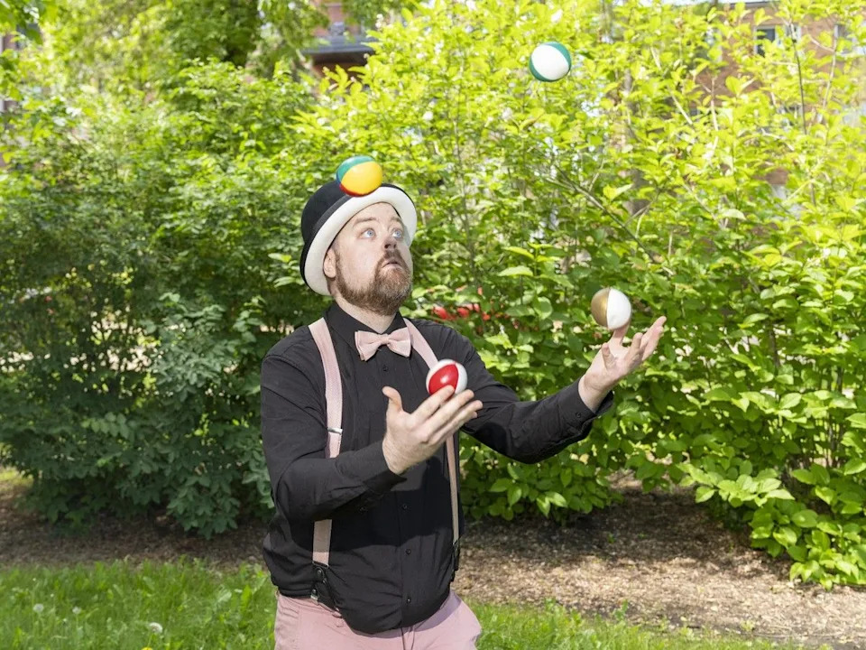 Street performer Charlie Peters demonstrates juggling to Justin Bell (not pictured) on June 19, 2026.