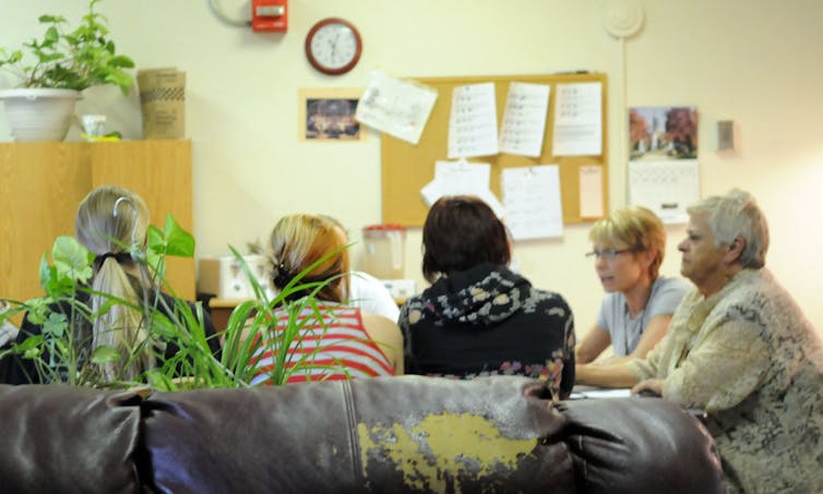 A group of people sit around a table in a medical facility.