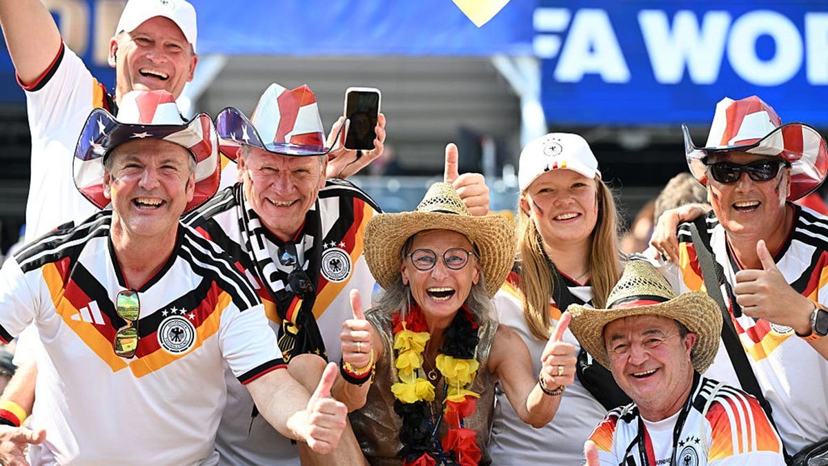 german fans wearing American flag hats give thumbs up to the camera