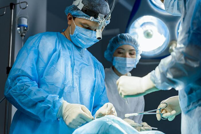 Surgeons performing an operation in a brightly lit operating room, representing the medical industry.