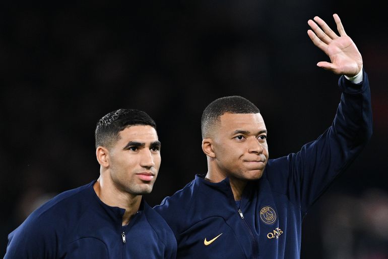 PARIS, FRANCE - OCTOBER 25: Achraf Hakimi and Kylian Mbappe of Paris Saint-Germain wave as the players of Paris Saint-Germain line up for the UEFA Champions League anthem prior to the UEFA Champions League match between Paris Saint-Germain and AC Milan at Parc des Princes on October 25, 2023 in Paris, France. (Photo by David Ramos/Getty Images)
