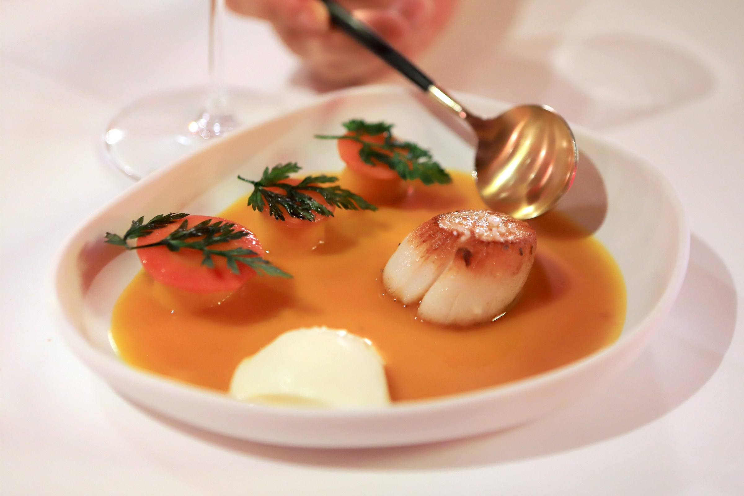 RIQUEWIHR, FRANCE - OCTOBER 11: A dish of Coquille Saint-Jacques (Scallops) is served with glazed carrots in a cream of carrot sauce in French chef Jean-Luc Brendel’s Michelin-starred restaurant La Table du Gourmet on October 11, 2019 in the village of Riquewihr in the Alsace region of eastern France. Alsace is famous for its unique cuisine, the high number of picturesque villages, churches and castles, the Vosges mountains and its vineyards with the 170 km of the Route des Vins d’Alsace. (Photo by David Silverman/Getty Images)