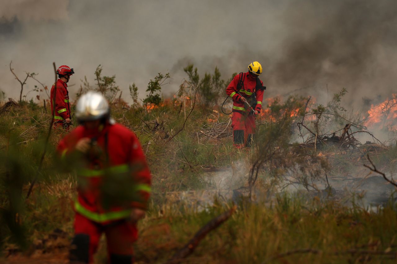 Firefighters survey the scene of a fire in Marcheprime, west of Bordeaux, France on Sunday.