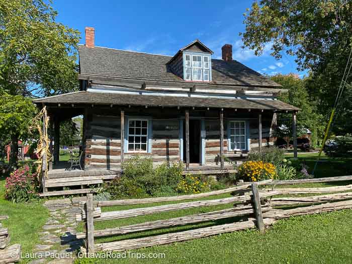 log cabin with a split-rail fence out front