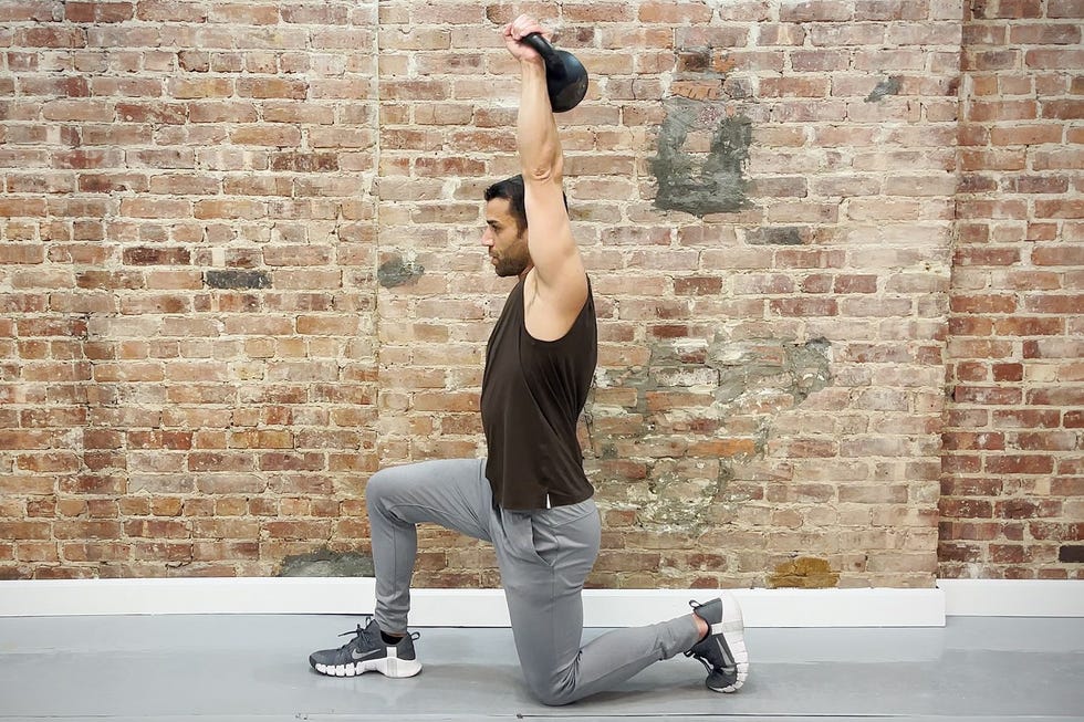 tamir practicing the halfkneeling singlearm overhead press exercise