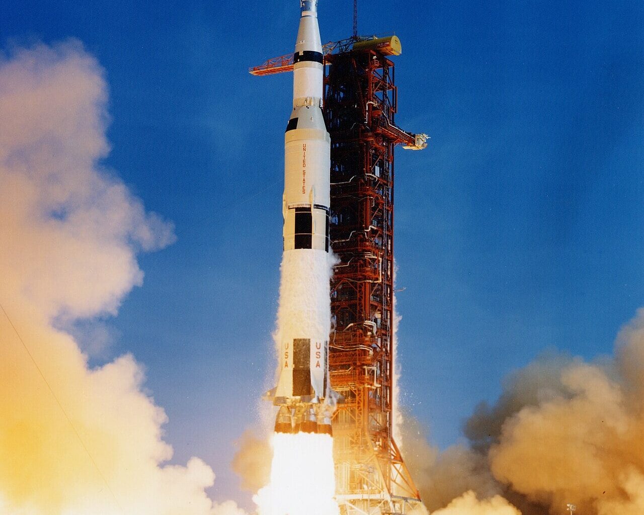 A Saturn V rocket accelerates off the pad. Sustained acceleration is exactly what conjures the faint quantum glow of Unruh radiation. Credit: NASA (public domain).