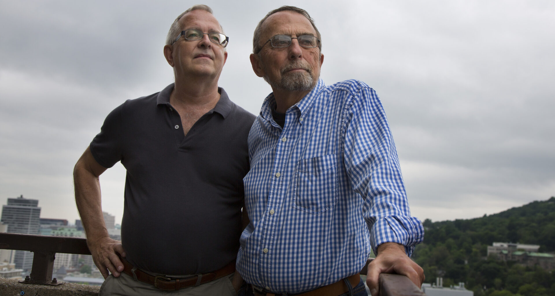 Two men standing on balcony.