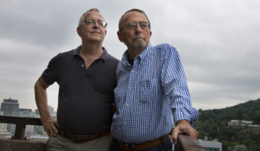 Two men standing on balcony.
