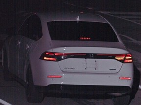 The rear view of a white Honda Accord with no licence plate.