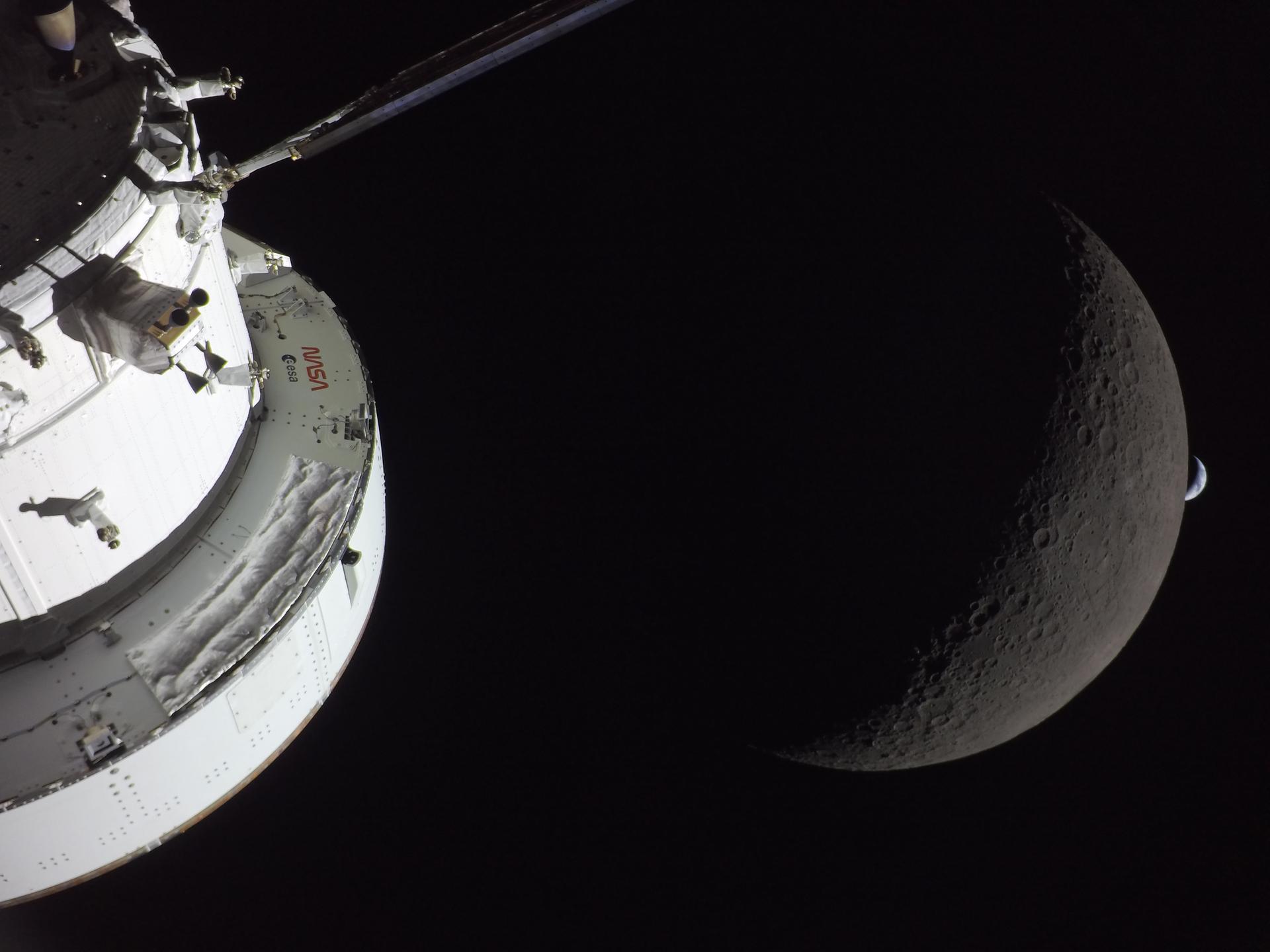 Camera on the Orion capsule (foreground) see the Earth setting behind the moon