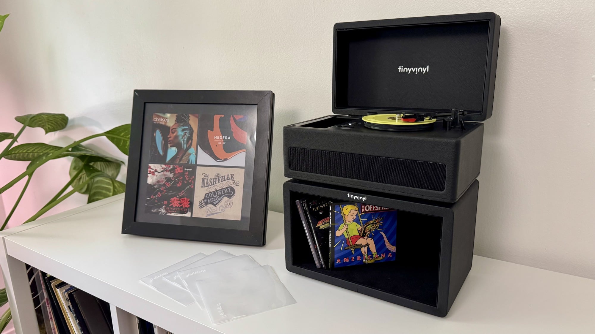the tiny vinyl player, crate, and display stand on a white media console