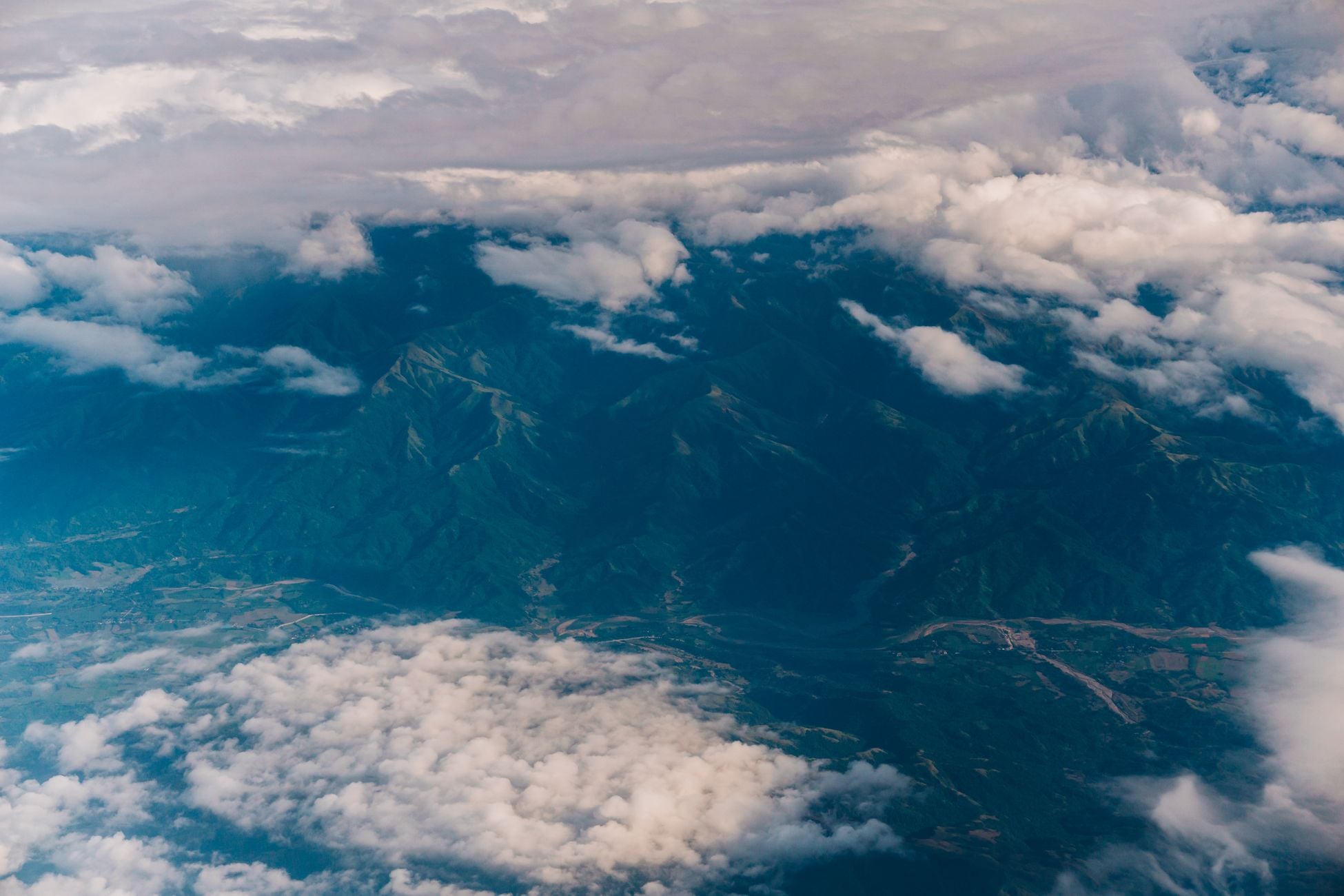 Captivating aerial photograph of mountains covered by clouds, showcasing natural beauty.