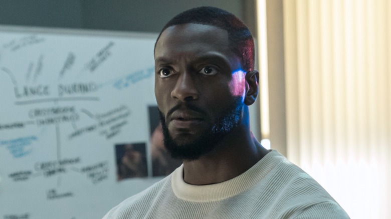 Detective Alex Cross standing in front of a case board in Cross Season 2