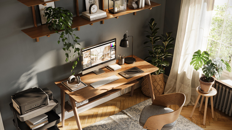 A professional photo of an elaborate, aesthetic desk setup next to a window during the day