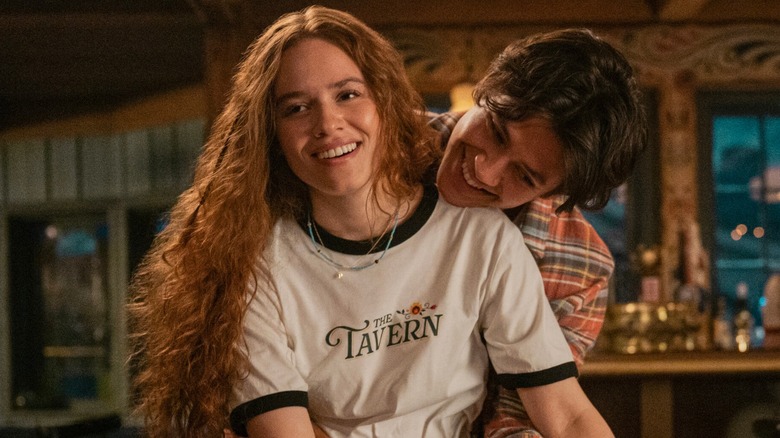 Sam Florek standing behind Percy Fraser with his arms around her waist in Every Year After