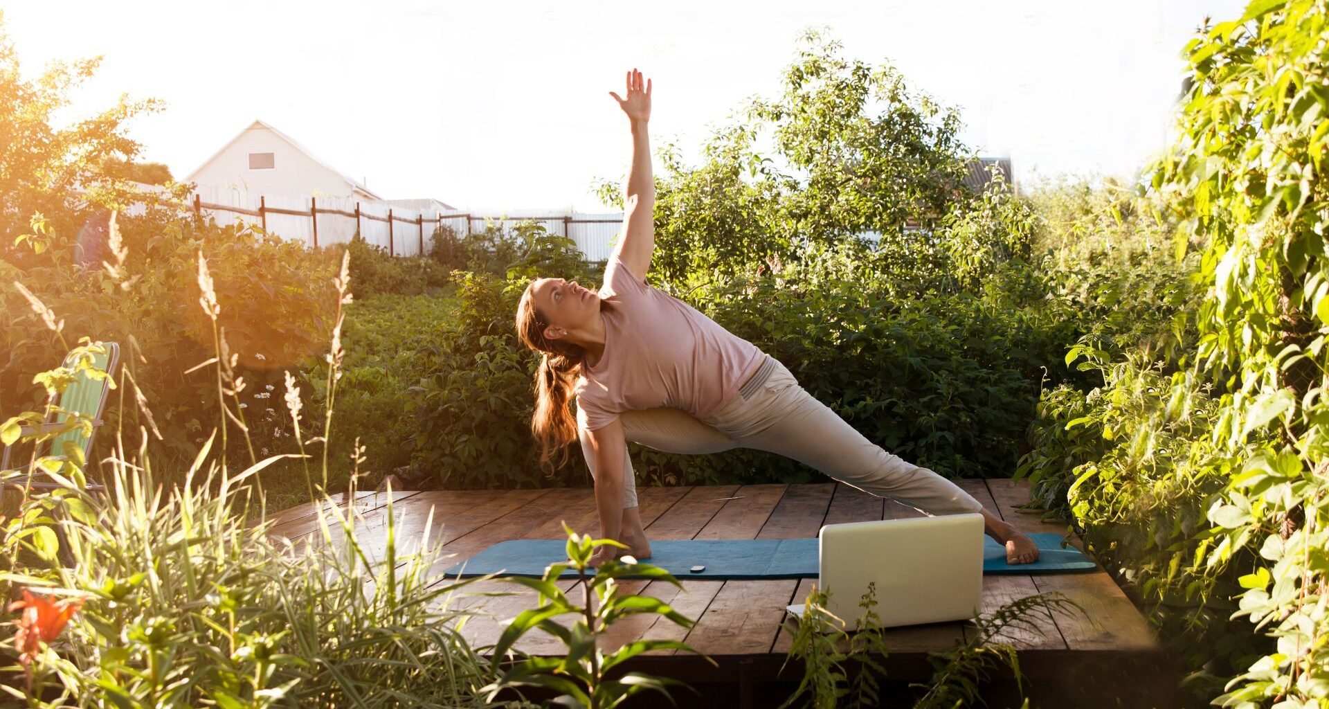 Woman doing yoga workout on mat in garden