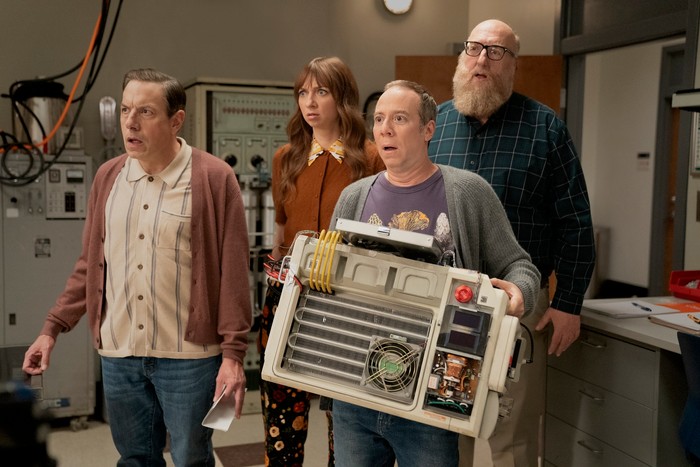 Stuart Fails to Save the Universe (L-R) John Ross Bowie, Lauren Lapkus, Kevin Sussman and Brian Posehn star in Stuart Fails to Save the Universe; their characters are standing in a row, looking shocked and worried at something ahead of them. Stuart is holding a large technological instrument.