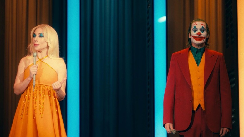 Harleen (Lady Gaga) and Arthur (Joaquin Phoenix) hosting a talk show in Joker: Folie à Deux
