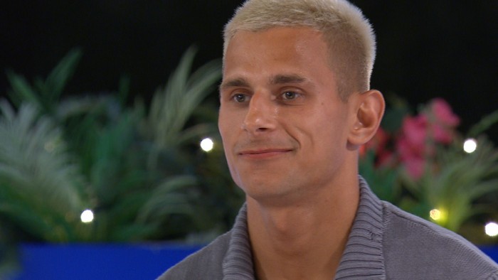 Love Island S13 A close up of Sean smiling while stood at the Love Island firepit.
