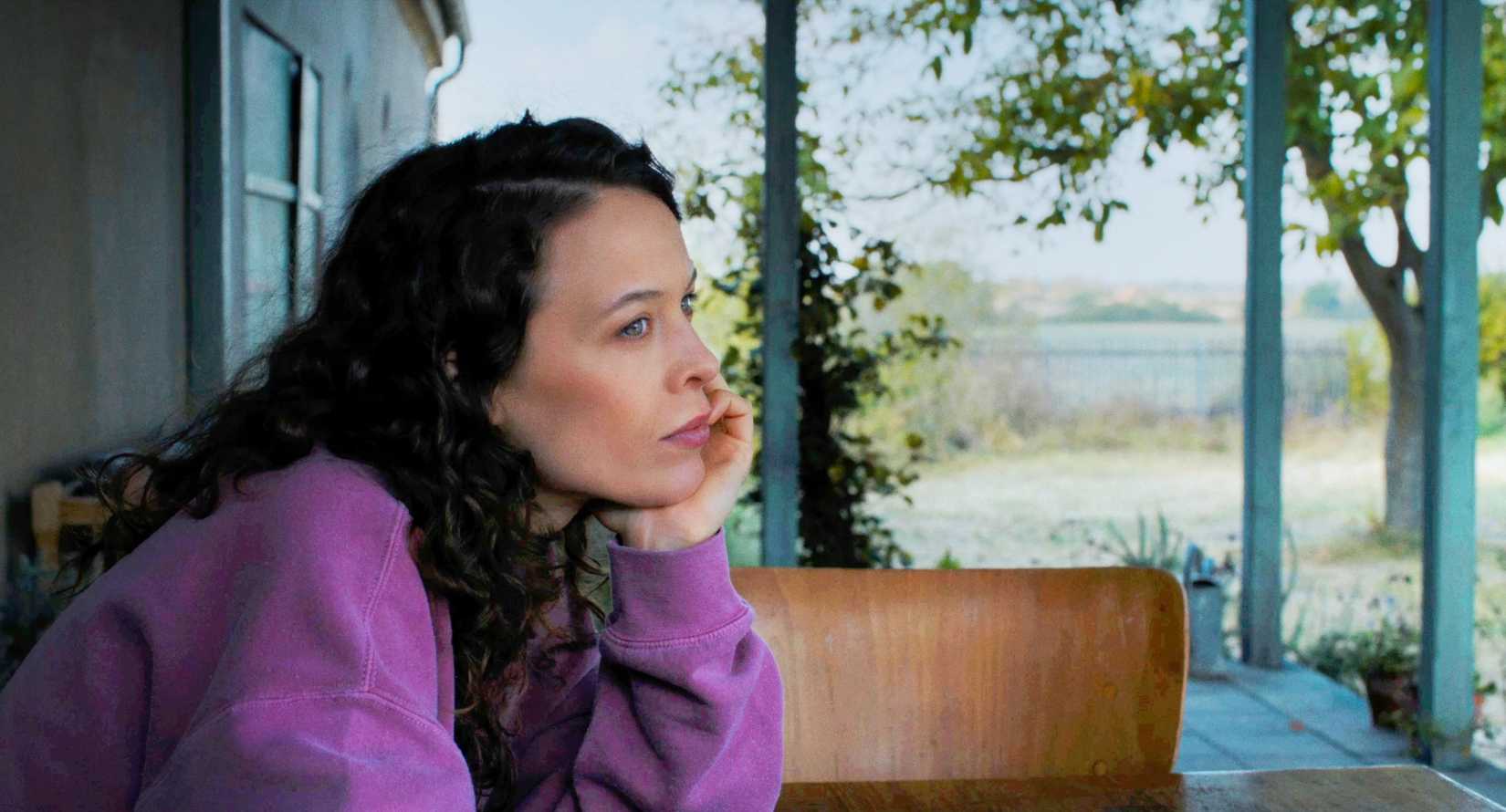 A woman wearing a purple sweater in Miroirs no. 3