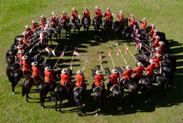 mounties in red serge on black horses in a circle